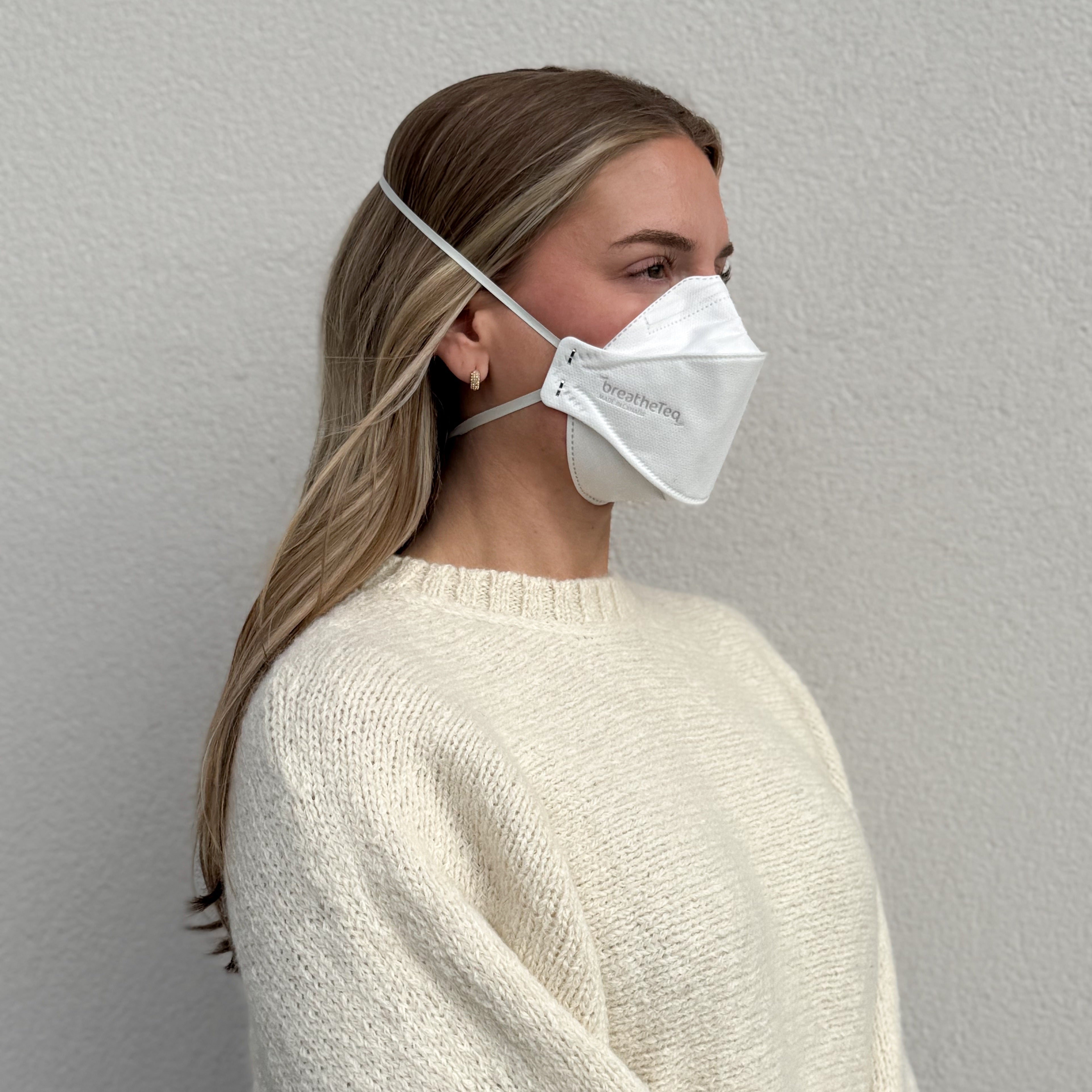 side profile woman wearing BreatheTeq white KN95 breathable headband respirator trifold mask - not NIOSH N95
