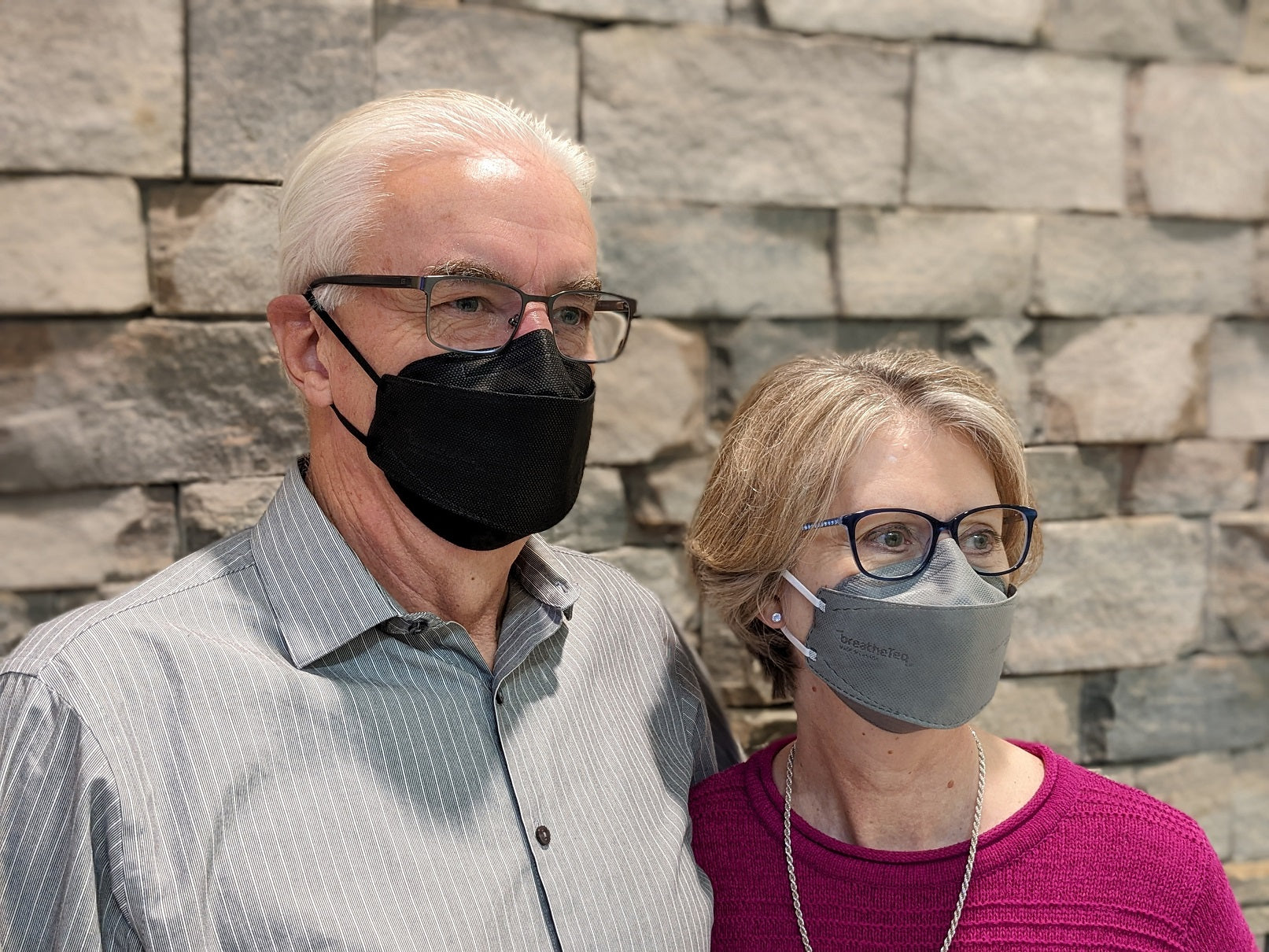 Man wearing large black KN95 and woman wearing medium grey KN95 breatheteq with earloops Made in Canada