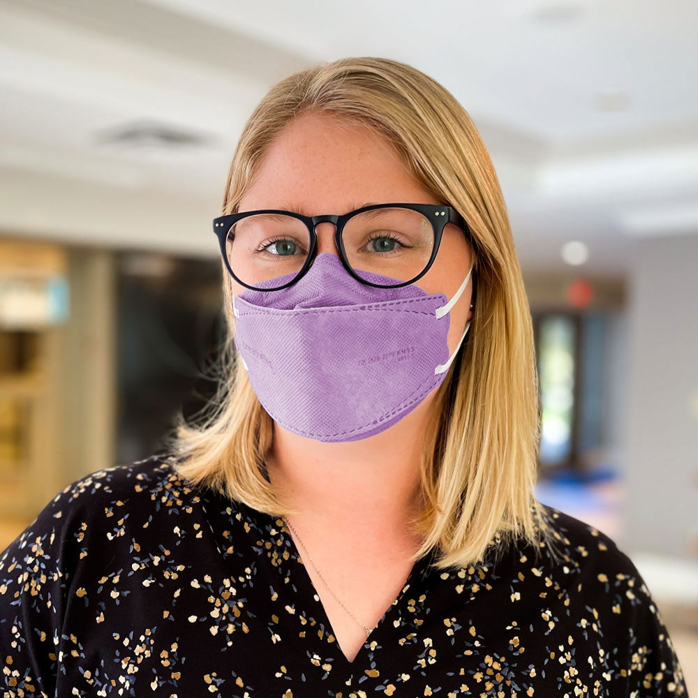 Woman with glasses wearing BreatheTeq KN95 large purple Canada Masq respirator face mask made in canada by Canada Strong