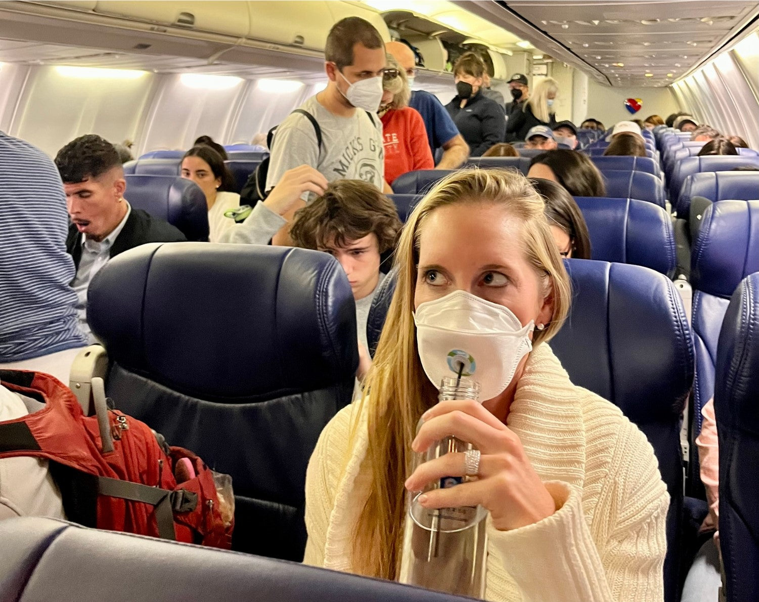 Person drinking on an airplane with SIP face mask valve