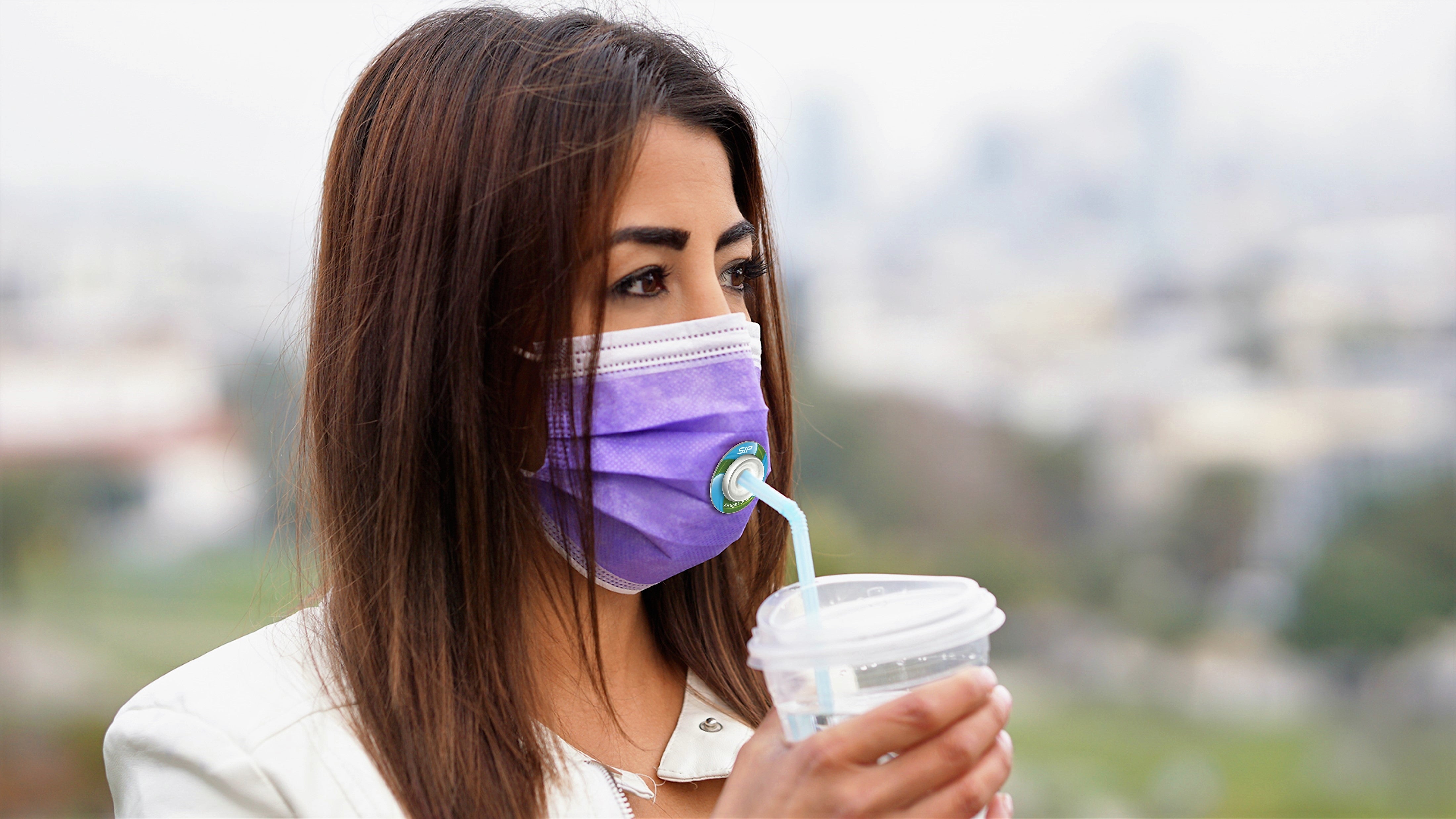 Canadian woman drinking through level 3 procedure mask using SIP valve and straw.